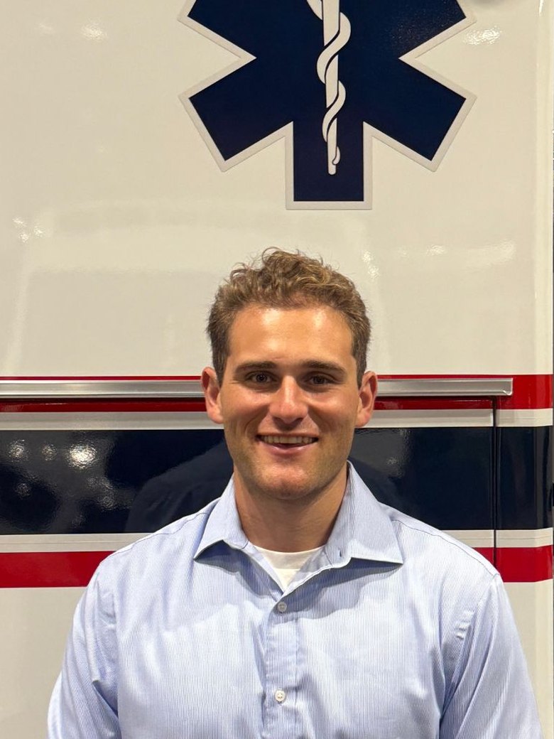 Jordan Appelbaum, founder of AfterCall, in front of an ambulance at EMS World